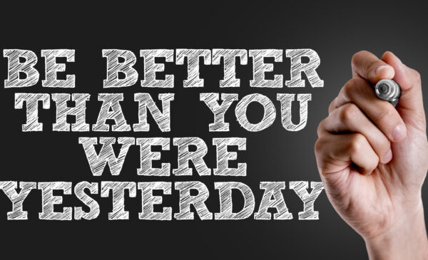 Hand writing the text: Be Better Than You Were Yesterday